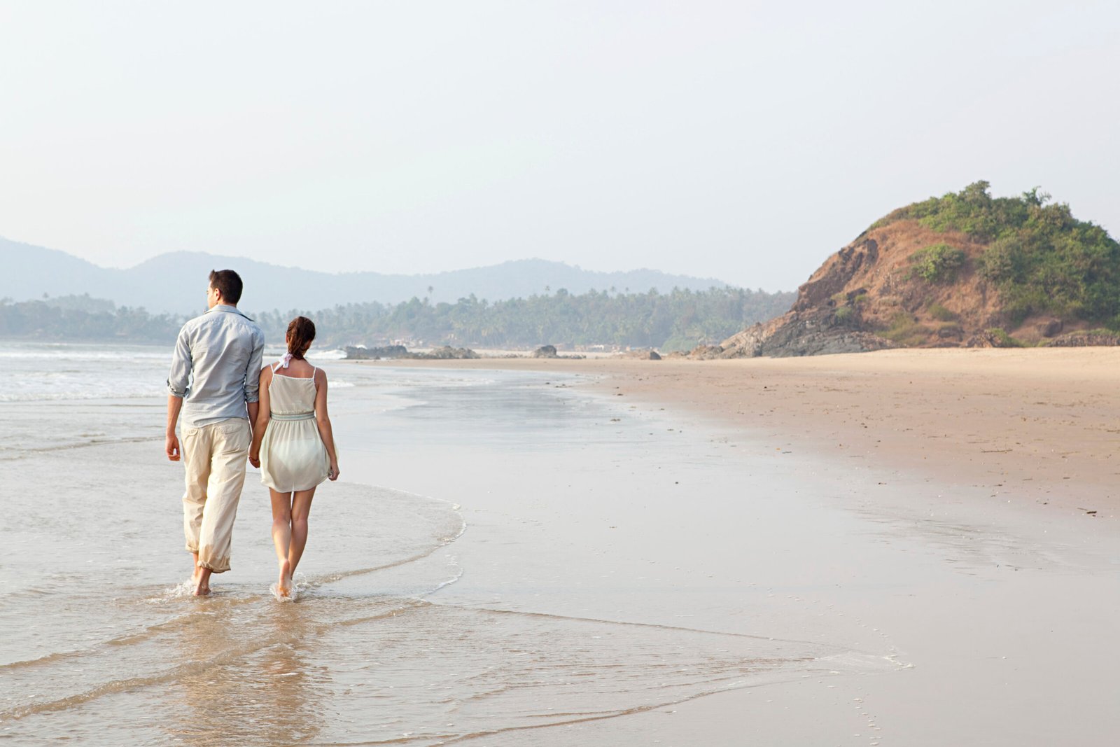 Couple enjoying a serene beach walk at sunset