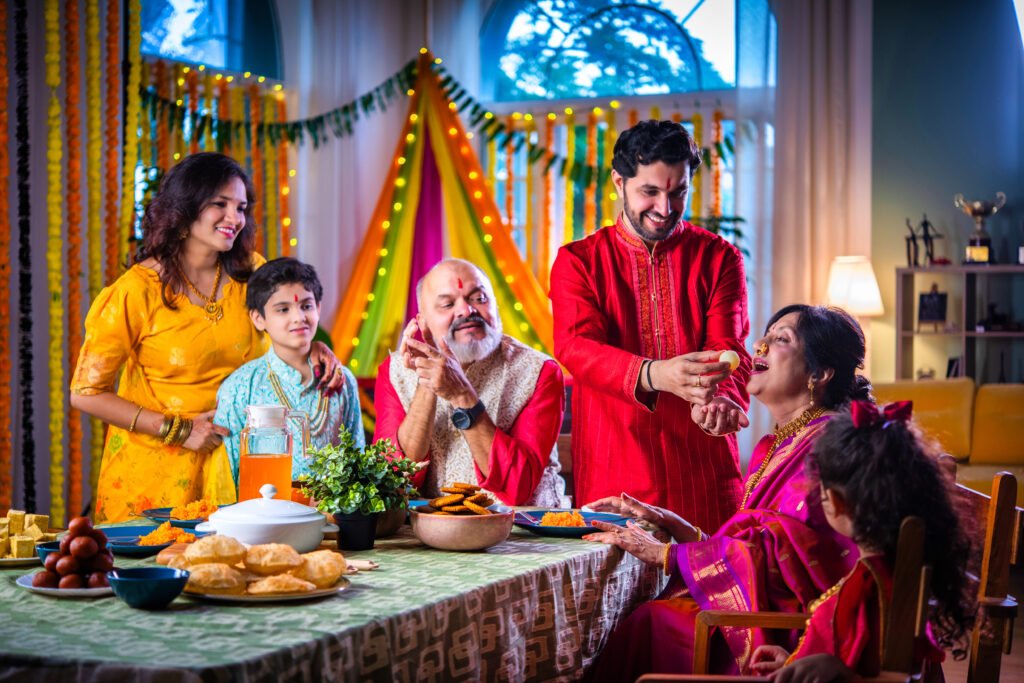 Big Indian Asian Hindu Family Celebrating Diwali or Ganesh festival in Traditional Clothes Gathered Together on a Dinner Table eating or taking selfie picture, having fun